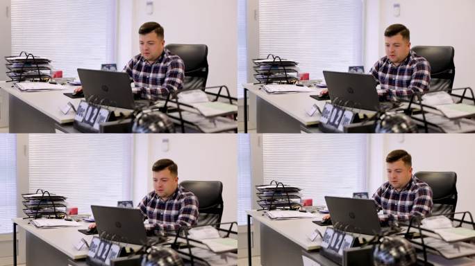 在办公室里，年轻而忙碌的商人正在使用笔记本电脑