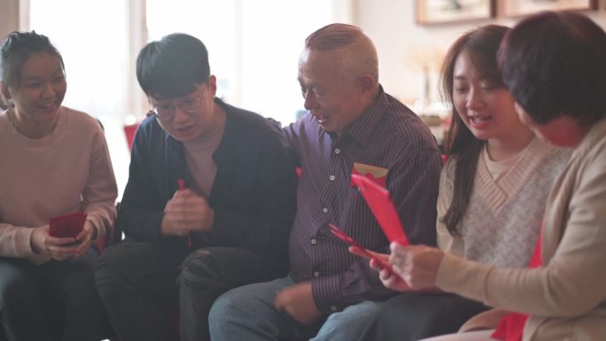 中国新年的孙辈们祝福他们的祖父母收到红包，财源滚滚，好运连连