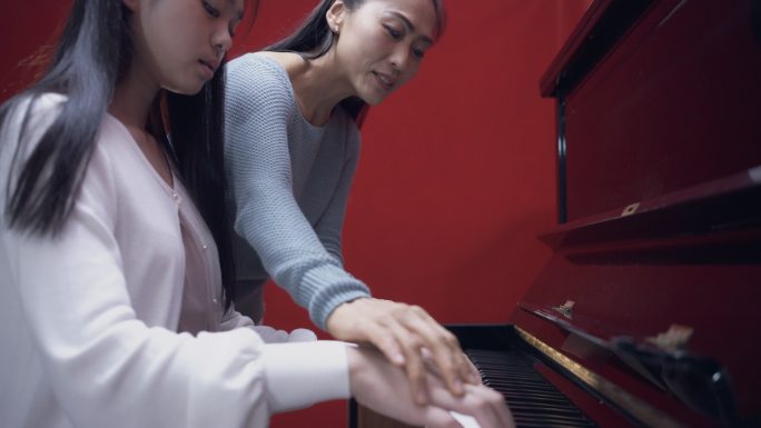 亚洲女音乐导师，与她的学前班女学生一起工作。