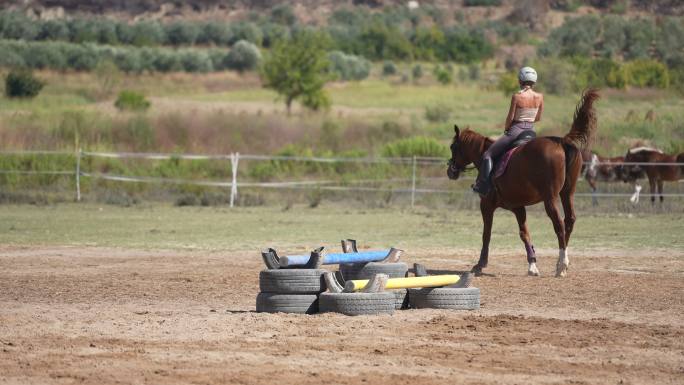 在马术学校练习骑马的年轻女士