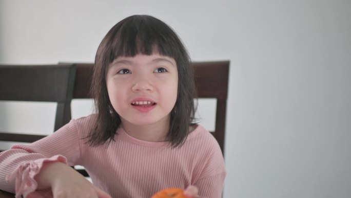亚洲中国年轻女孩看着笔记本电脑摄像头，用红包和橘子向祖父母问候中国新年