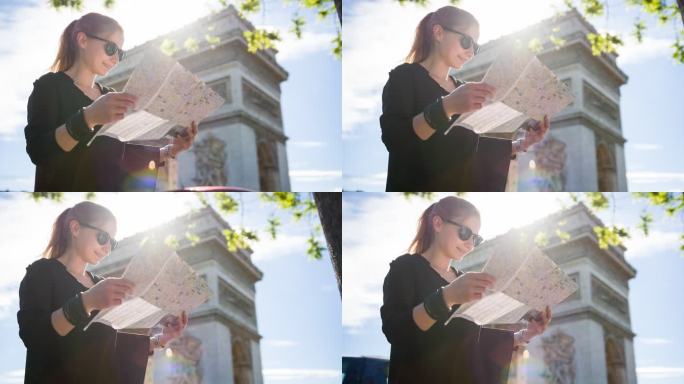 游客站在巴黎凯旋门前，阅读城市地图