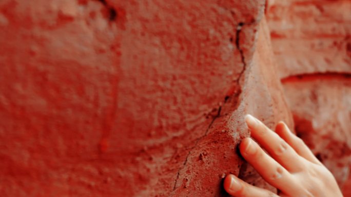 手抚摸红色的岩石 探索自然 感受自然