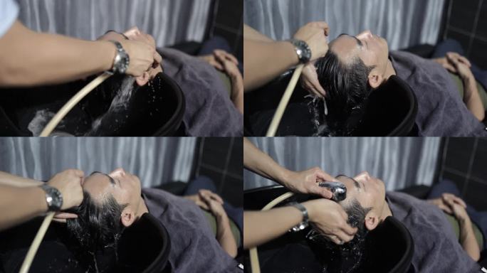 亚洲华人发型师在美发沙龙为顾客洗头