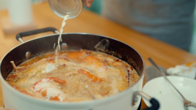 夫妇使用笔记本电脑学习制作泰国美食。