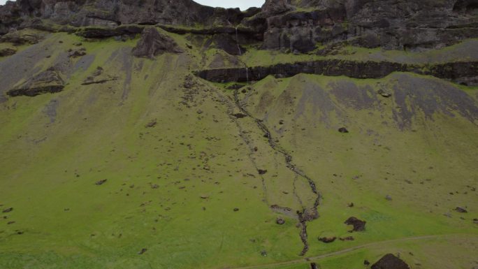 无人机拍摄典型农场棚，瀑布从冰岛南部山区坠落