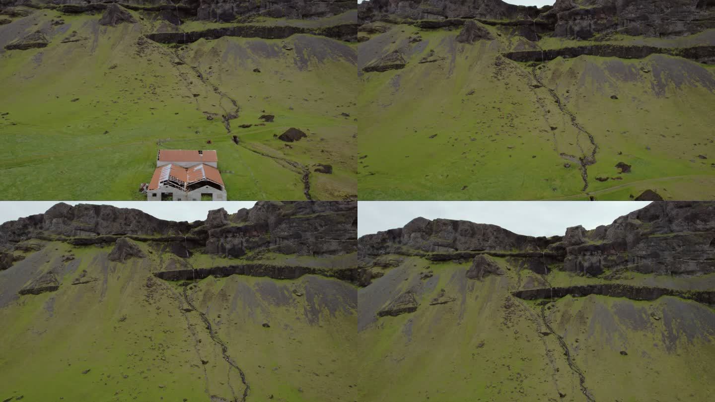 无人机拍摄典型农场棚，瀑布从冰岛南部山区坠落