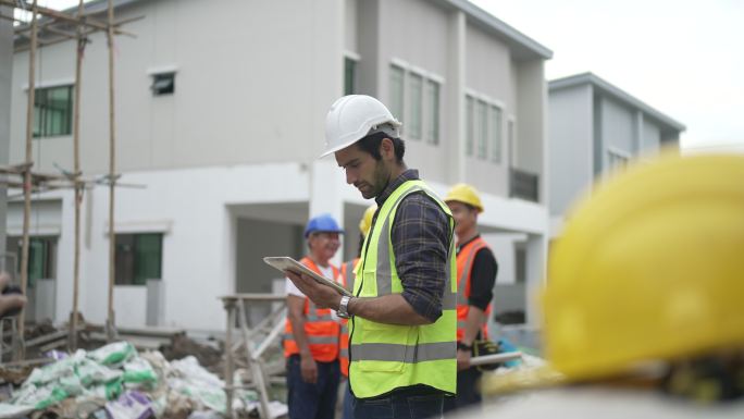 蓝领工人正在建筑工地与同事一起工作。