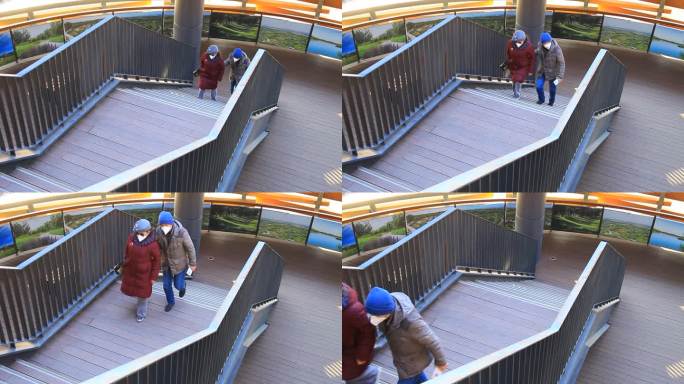 冬季两位老人搀扶上楼梯从楼梯上经过实拍