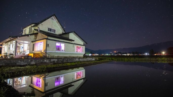 乡间别墅倒映在水中夜晚的星星时光流逝