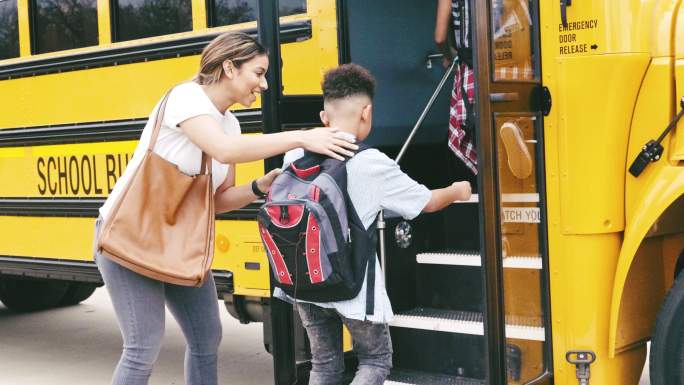 中年妈妈帮助儿子在开学第一天登上校车