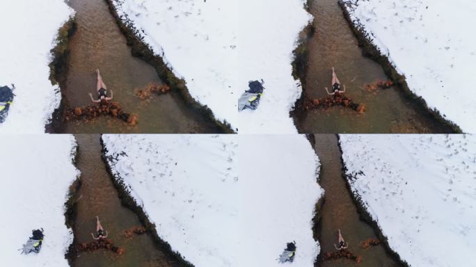 图为冰岛，一位身着泳衣的女士躺在雪景中的温泉中