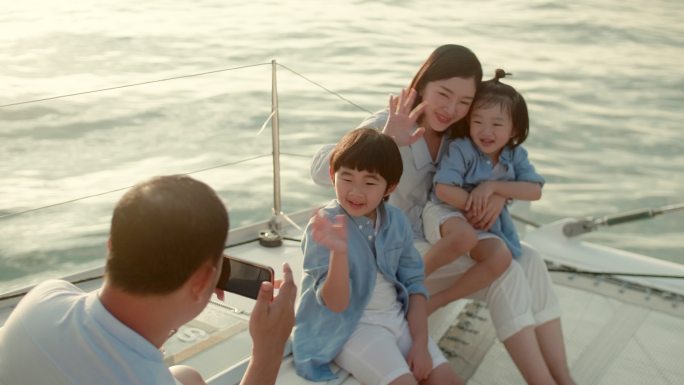 日落时分，游艇上幸福的一家人对着镜头微笑
