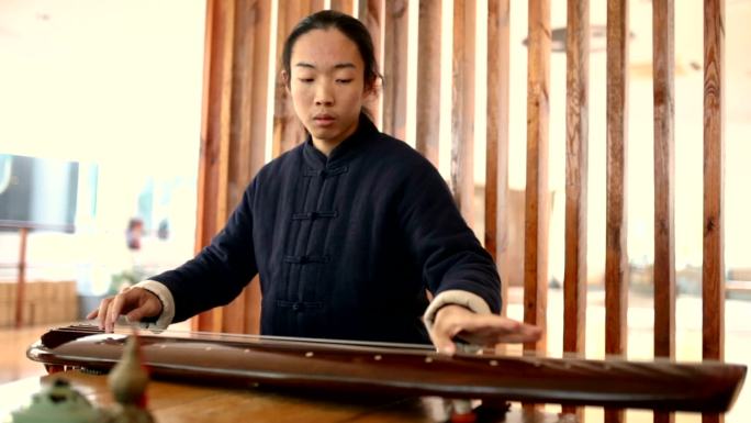 亚洲男子在太极学校演奏古琴