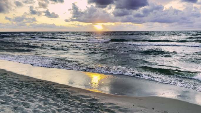 海滩上美丽的日落晚霞海浪海边沙滩浩瀚大海