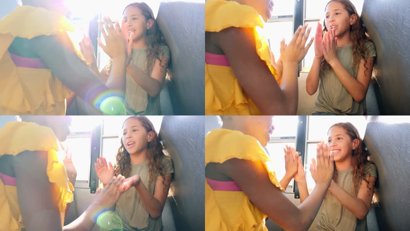 快乐的女学生在校车上玩拍手游戏