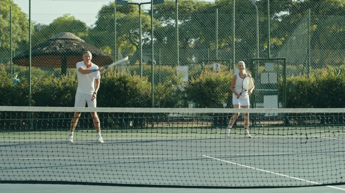 一对老年夫妇在网球场上打双打