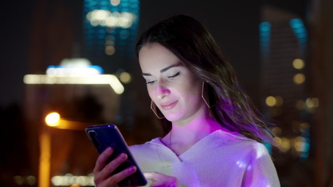 在城市里使用智能手机的年轻女性
