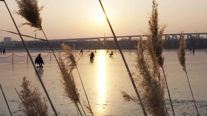 夕阳下逆光中滑冰车的游客