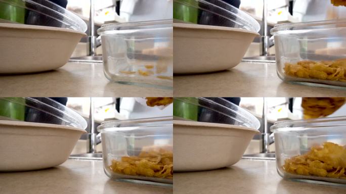 将谷物早餐玉米片加入玻璃容器