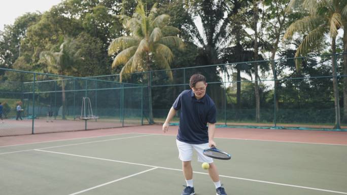 亚洲中国羽绒综合症男子网球运动员周末上午在网球场练习