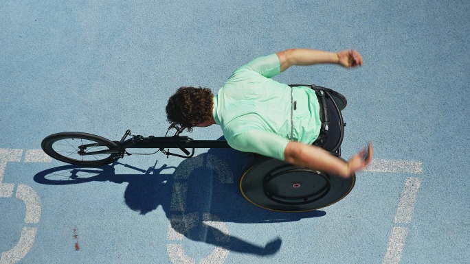 男子轮椅运动员在阳光充足的跑道上伸展