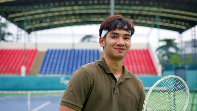 年轻的网球运动员微笑着站着