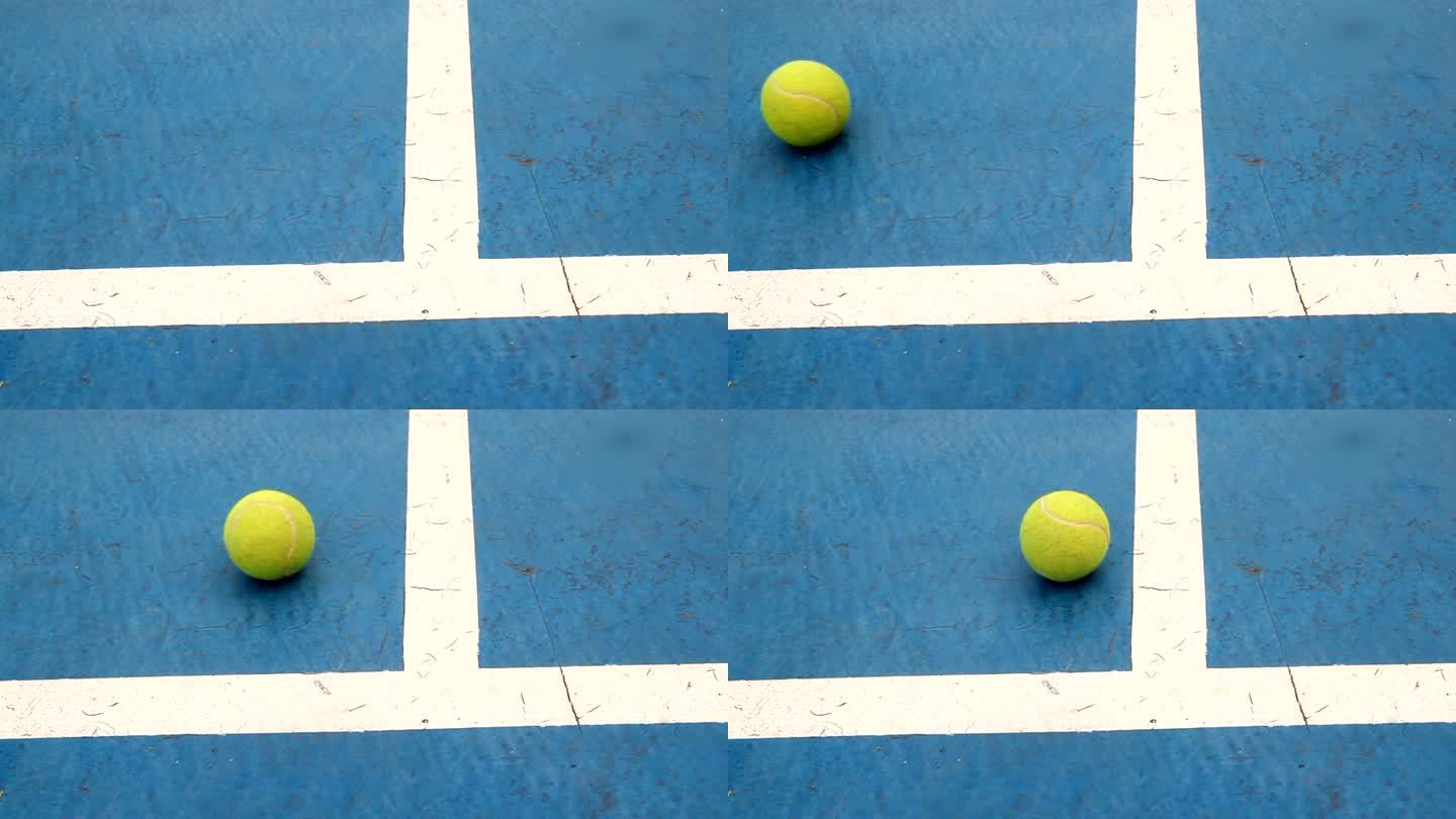 蓝色球场上的网球滚动掉落打球