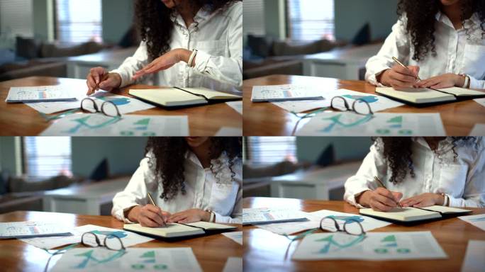 女性手在笔记本上写字时做笔记和看文书图表的特写。企业家坐在办公桌前，处理分析统计数据和记录财务支出的