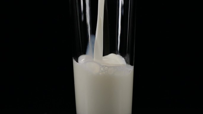 倒牛奶慢动作牛奶倒入玻璃水杯黑色背景广告