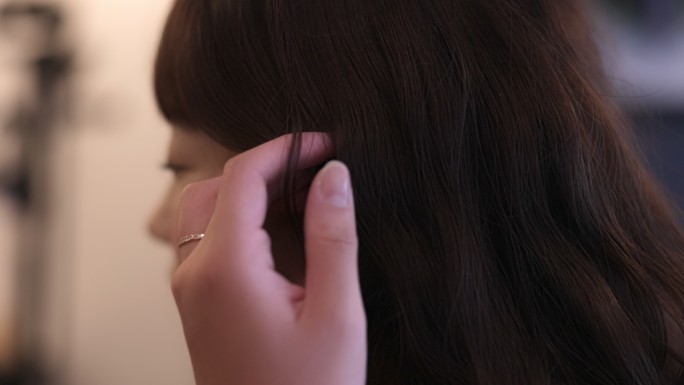 女人抚摸头发和播种耳环的特写