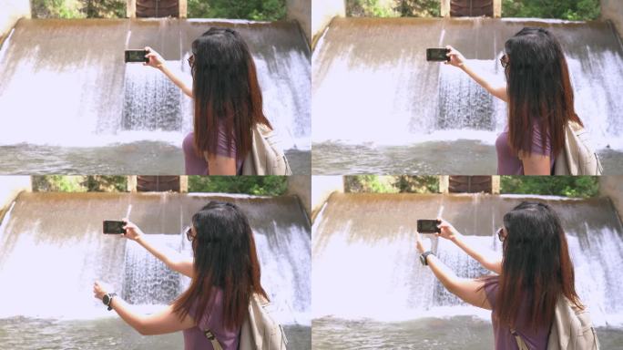 亚洲妇女在非城市农业场景中的当地堰上，山脉，拍摄瀑布般的漂浮水照片，泰国北部，心情激动，情绪积极