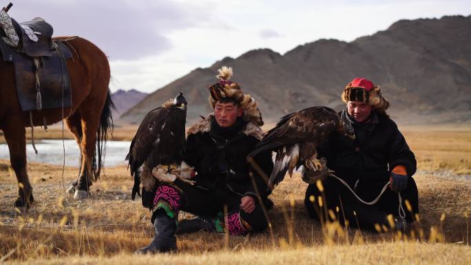 蒙古河流附近的两名老鹰猎人的肖像