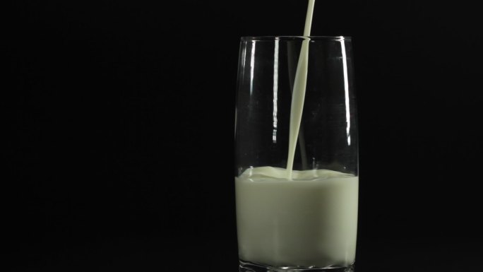 倒牛奶特写牛奶倒入玻璃水杯黑色背景广告片