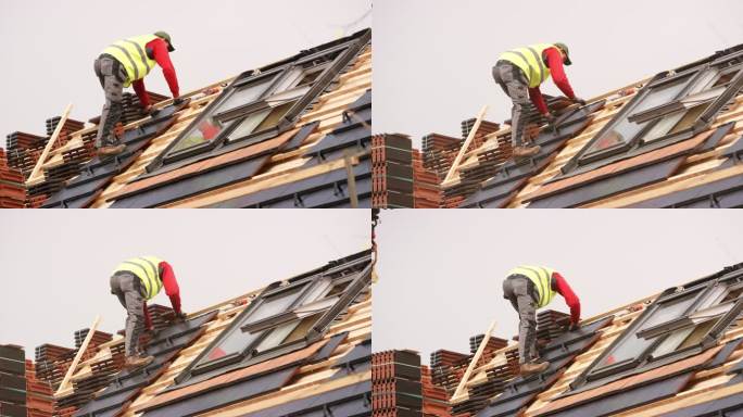 在新建建筑上铺设屋顶瓦的男屋顶工