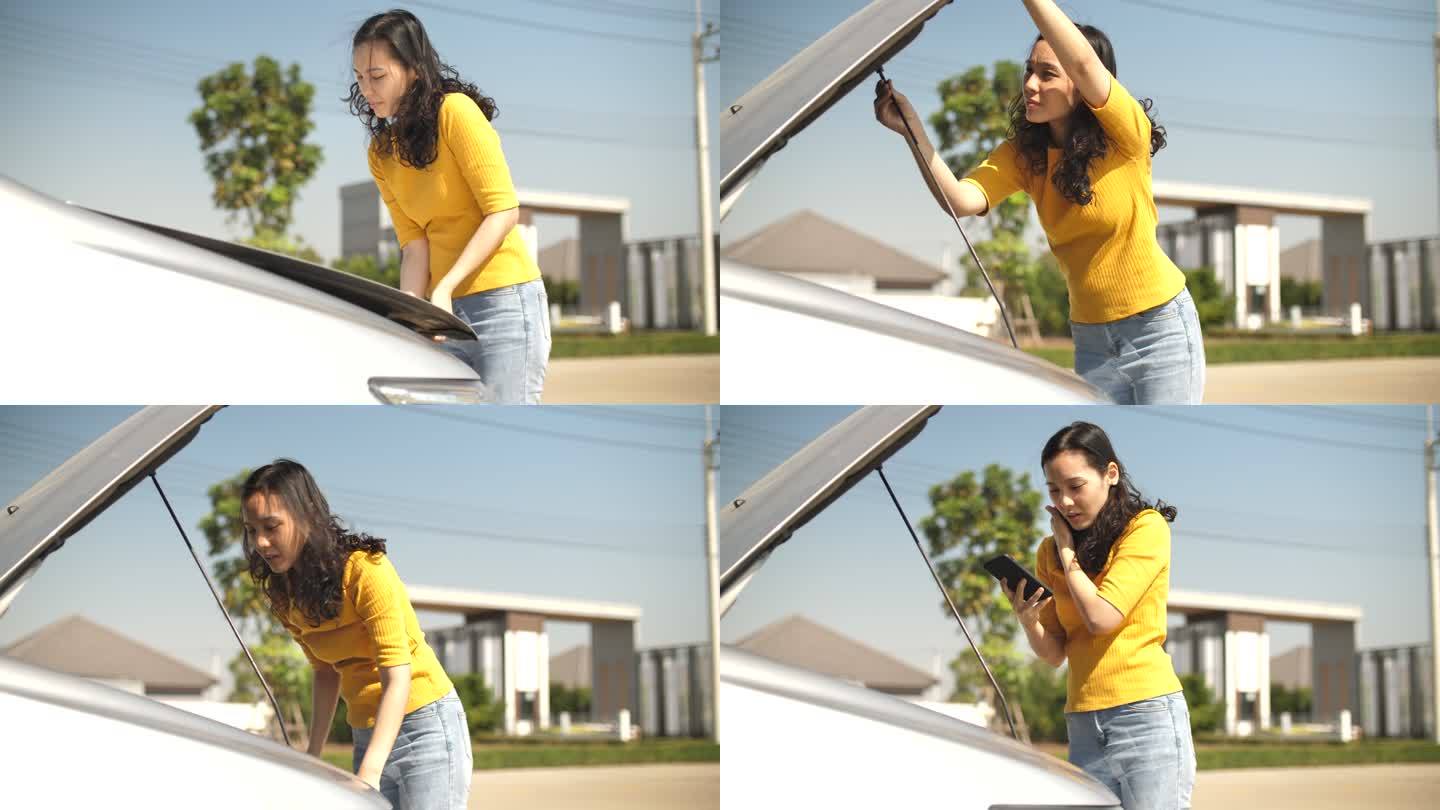 亚洲女人打开散热器盖汽车看到发动机并打电话给保险公司