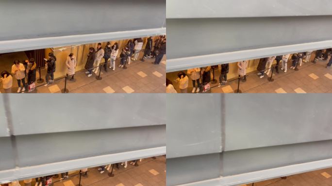 电梯俯瞰商场广场排队买爆款的人群.