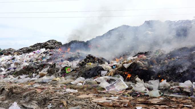 垃圾堆着火了。污染概念。大山垃圾回收场。