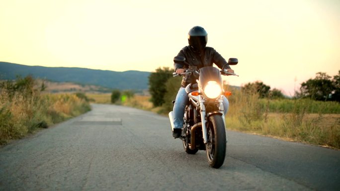 日落时分骑摩托车在空旷的道路上骑行