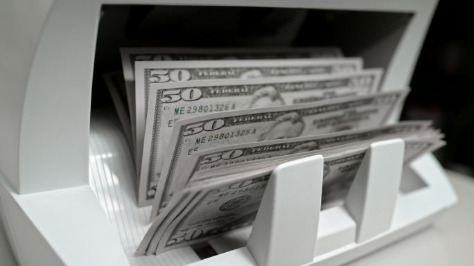 SLO MO LD推动者在货币柜台上将50美元钞票推到堆垛机上