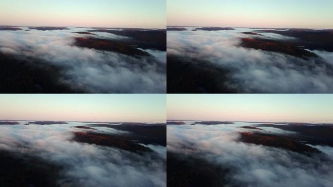 美丽的空中全景，在色彩斑斓的日出中被雾笼罩。