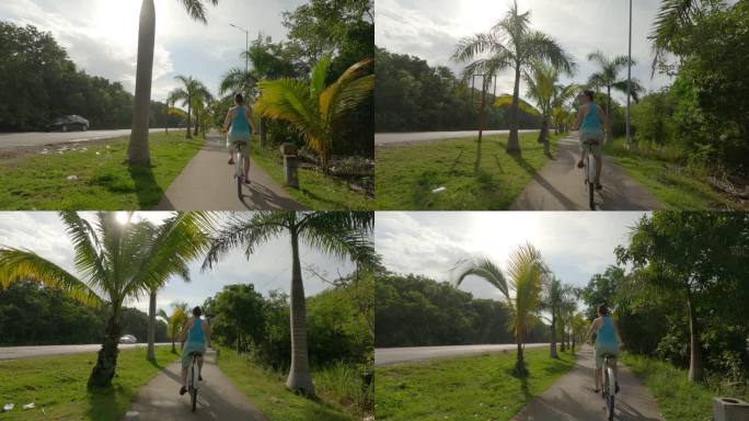 妇女骑自行车沿着丛林小路，路边
