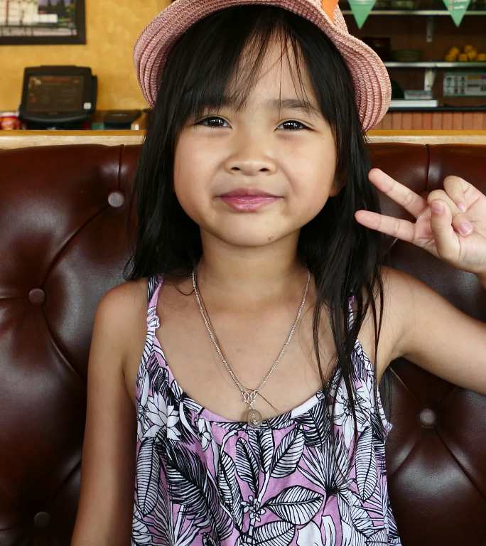 7岁女孩举起手指小女孩比耶开心拍照