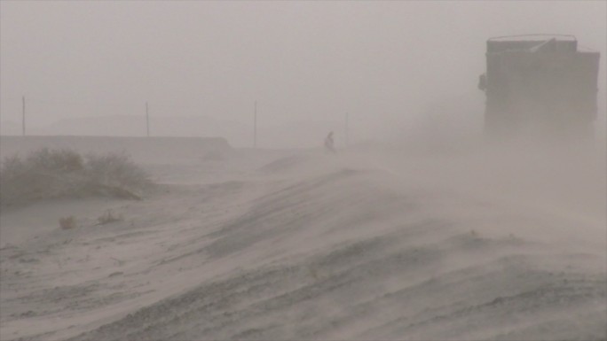 新疆 沙尘天气 车辆经过时的路面风沙