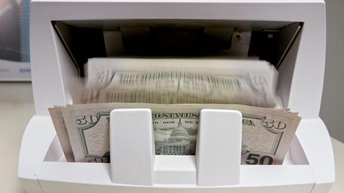 LD 50美元钞票从点钞机出来并堆积在一起
