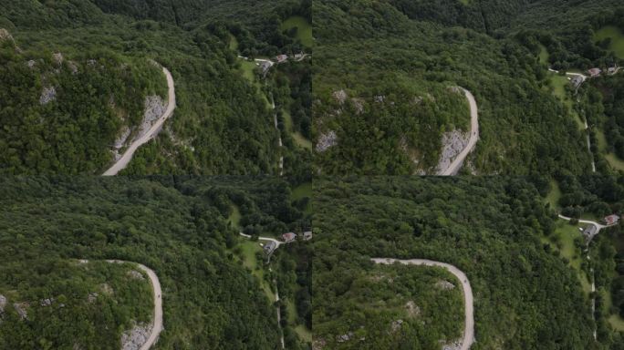 摩托车在山坡上蜿蜒的乡村公路上行驶的鸟瞰图