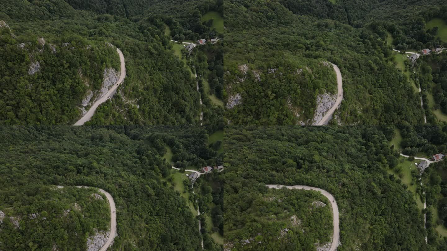 摩托车在山坡上蜿蜒的乡村公路上行驶的鸟瞰图