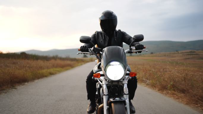 骑摩托车旅行。阴天日落时的乡村景观