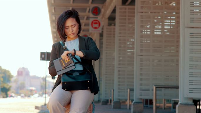 4k视频画面显示，一名年轻女商人在城市外焦急地等待迟到的出租车