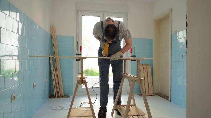 熟练的高加索男性木匠用拼图切割木材